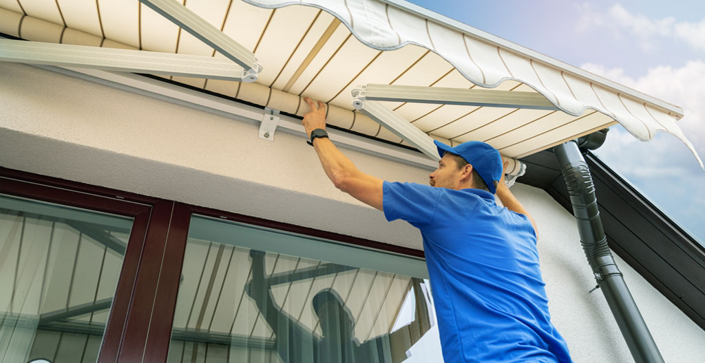 Propietario midiendo distancia techo-pared en terraza con cinta métrica